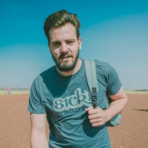 Young man with backpack outdoors on a clear day for Yellowcake Games presskit.